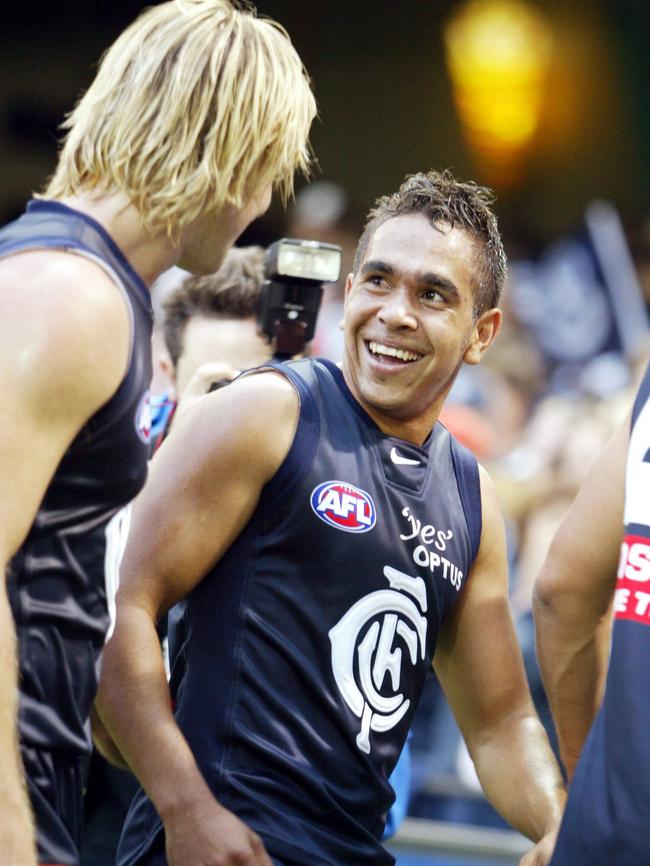 A smiling Eddie Betts walks off the ground with former teammate, Crows assistant and now Carlton coach David Teague.