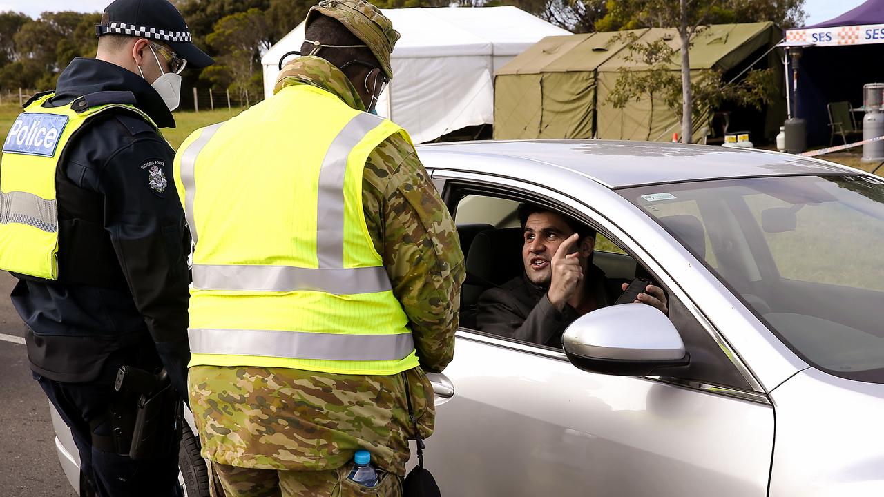 Victorian Police and Australian Defence Force personnel speak to a driver at a vehicle checkpoint. Picture: NCA NewsWire / Ian Currie