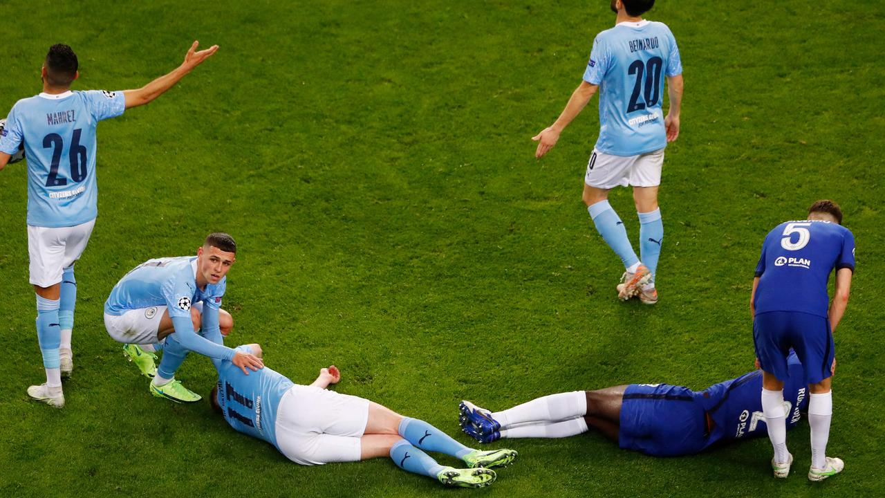 TOPSHOT - Chelsea's German defender Antonio Ruediger (R) and Manchester City's Belgian midfielder Kevin De Bruyne (L) react in pain after a collision during the UEFA Champions League final football match between Manchester City and Chelsea at the Dragao stadium in Porto on May 29, 2021. (Photo by SUSANA VERA / POOL / AFP)