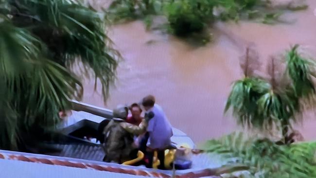 SKY TV frame grabs of a live rescue from the top of a home in Lismore by the defence force - a woman was airlifted to a helicopter