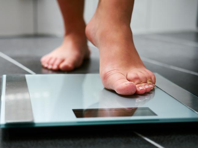 Female bare feet with weight scale in the bathroom, scales generic