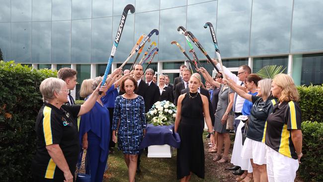 Hockey players form a guard of honour as pallbearers Jodie Holmes and Bonnie-Ray Pirie help carry the coffin to the waiting hearse. Picture: Glenn Hampson