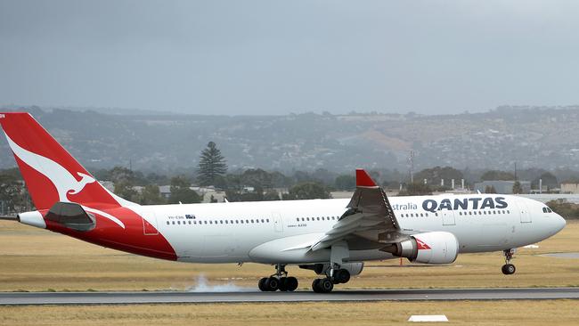 (FILES) This picture taken on December 10, 2013 shows a Qantas flight landing at the Adelaide airport in Adelaide. Struggling Australian airline Qantas will make dozens of pilots redundant for the first time in 40 years, reports said on May 14, 2014, as it looks to slash costs to contain massive losses. AFP PHOTO / FILES /Saeed KHAN