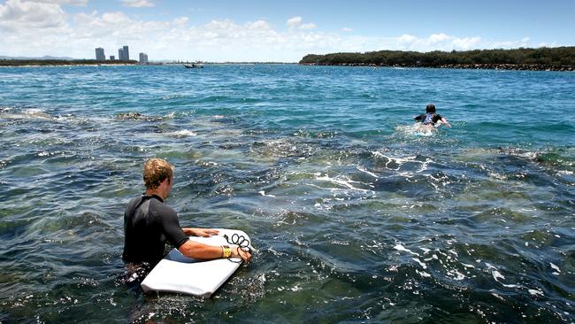 Body boarders paddle across to South Stradbroke Island. Pic by Luke Marsden.