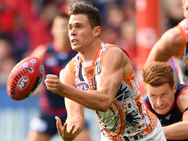 MELBOURNE, AUSTRALIA - MAY 26: Josh Kelly of the Giants handballs whilst being tackled by Oskar Baker of the Demons during the round 10 AFL match between the Melbourne Demons and the Greater Western Sydney Giants at Melbourne Cricket Ground on May 26, 2019 in Melbourne, Australia. (Photo by Quinn Rooney/Getty Images)