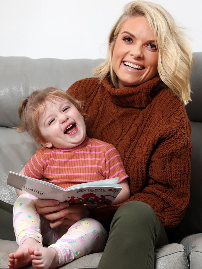 Erin Molan reading a book with her daughter Eliza. Picture: Jonathan Ng