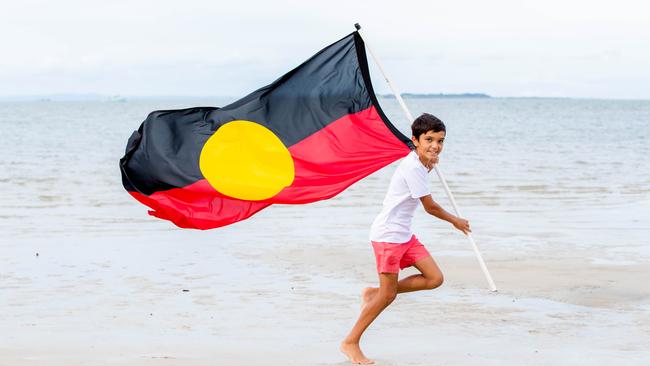 12-year-old Jamarley Edey runs with the Aboriginal Flag. Picture: Richard Walker