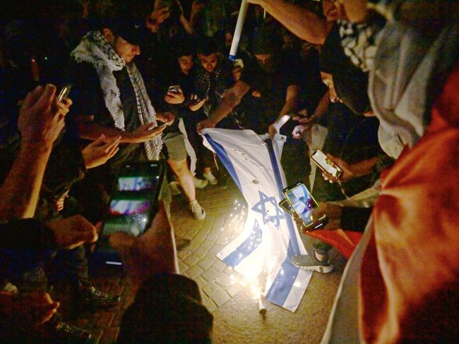 SYDNEY, AUSTRALIA - NewsWire Photos OCTOBER 9, 2023: ÃRally For A Free PalestineÃ protest burn the Israeli flag on the forecourt of The Sydney Opera House in Sydney following the recent outbreak of war between Israel and Palestine. Picture: NCA NewsWire / Jeremy Piper