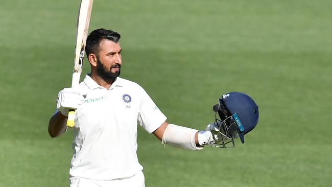 Cheteshwar Pujara raises his bat after reaching his century late on day one. Picture: AAP