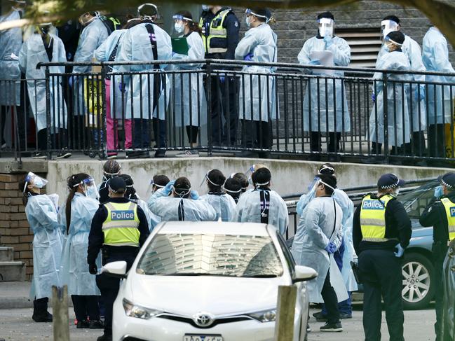 MELBOURNE, AUSTRALIA - JULY 08: Lines of Healthcare professionals are seen entering the North Melbourne Public Housing tower complex on July 08, 2020 in Melbourne, Australia. Further lockdown measures for residents in metropolitan Melbourne or the Mitchell shire will come into effect from 11:59 Wednesday 8 July. Under the new lockdown restrictions which will be in place for six weeks, people will only able to leave home have for exercise or work, to buy essential items including food or to access childcare and healthcare. Victorians cannot gather in groups of more than two or their household group, school holidays will be extended for at least a week. Retail can remain open and markets are permitted to open for food and drink only. Cafes, restaurants, pubs, clubs and bars are back to takeaway only. (Photo by Darrian Traynor/Getty Images)