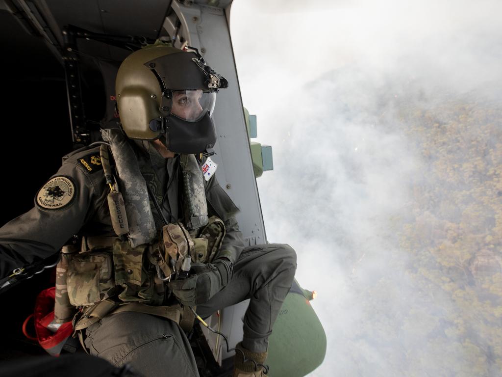 Royal Australian Navy Aircrewman Leading Seaman Ben Nixon of 808 Squadron, assesses the Tianjara Fire in the Moreton and Jerrawangala National Parks out of an MRH90 Taipan Military Support Helicopter. Picture: ADF