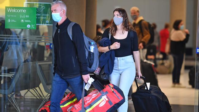 Travellers arrive at the Brisbane Airport with masks on as Queensland authorities announce even tougher Covid-19 restrictions. Picture: NCA NewsWire / John Gass