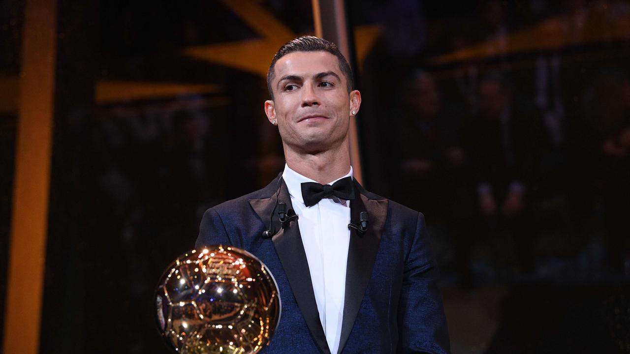 This handout photo released on December 7, 2017 by L'Equipe shows Portugese player Cristiano Ronaldo posing with the Ballon d'Or France Football trophy in Paris. Portuguese star Cristiano Ronaldo won a record-equalling fifth Ballon d'Or (2008, 2013, 2015, 2016 and 2017) award for the year's best player on December 7. The Real Madrid forward's second successive win draws him level alongside Barcelona rival Lionel Messi on five Ballon d'Ors, after beating the Argentinian and Brazilian Neymar. / AFP PHOTO / L'EQUIPE / Franck FAUGERE / RESTRICTED TO EDITORIAL USE - MANDATORY CREDIT "AFP PHOTO / L’EQUIPE / FRANCK FAUGERE" - NO MARKETING NO ADVERTISING CAMPAIGNS - DISTRIBUTED AS A SERVICE TO CLIENTS