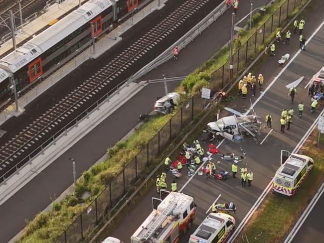 A car can be seen near train lines as emergency workers treat the injured. Picture: Picture: TNV