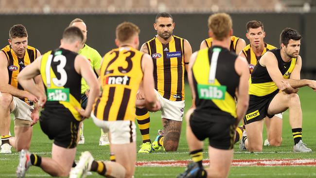 Richmond and Hawthorn players take a knee on Thursday night at the MCG.