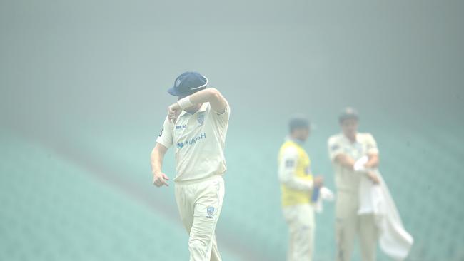 Players clear their eyes as smoke from the NSW bushfires. Picture. Phil Hillyard