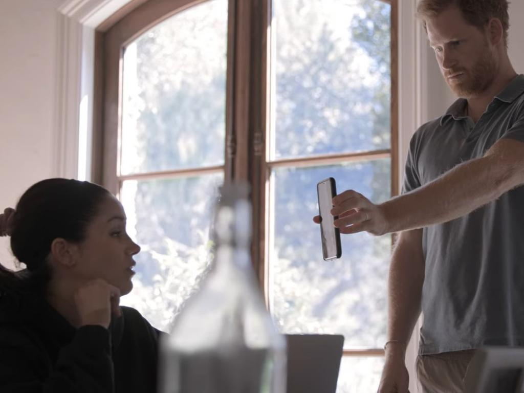 Prince Harry shows wife Meghan Markle a text he clams Prince William sent him in a scene from their Netflix docuseries. Picture: Netflix