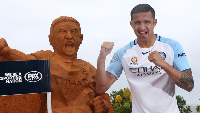 Tim Cahill at St Kilda Beach on Wednesday with a sand sculpture of himself.