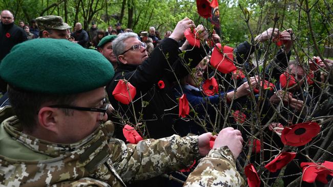 Ukrainians decorate a "memory tree" with paper red poppies to mark the "Day of Remembrance and Reconciliation" and the 78th anniversary of the victory over Nazism and the end of the World War II in Europe. Picture: AFP.