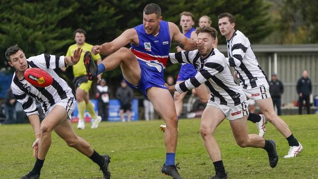 Outer East: Clinton Johnson throws his boot at the ball for Wandin. Picture: Valeriu Campan