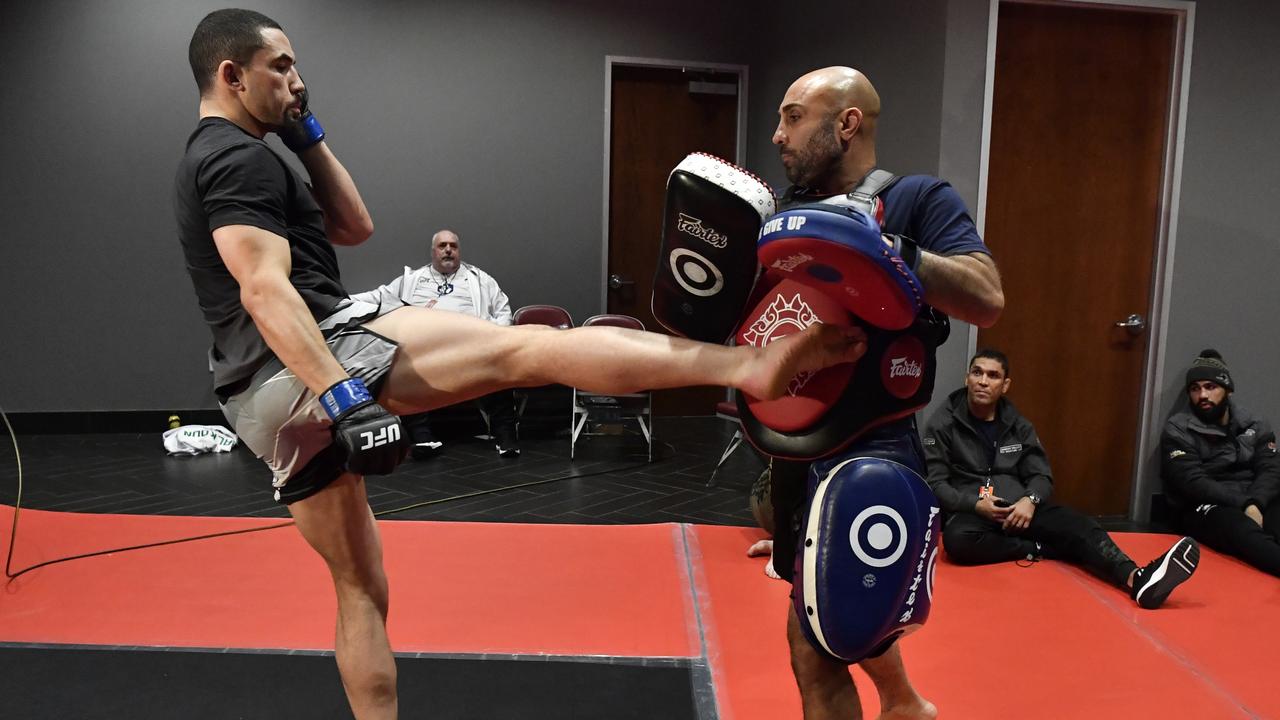 Malkoun (seated) wearing Panthers gear as Whittaker warms up in 2022. Picture: Mike Roach/Zuffa LLC