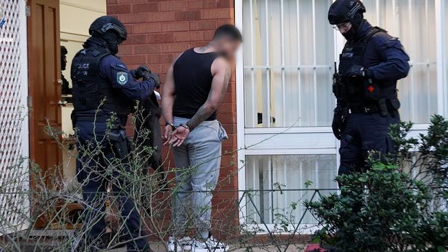 Police arrest a man after raiding a home at Birrong on Friday. Picture: NW Police