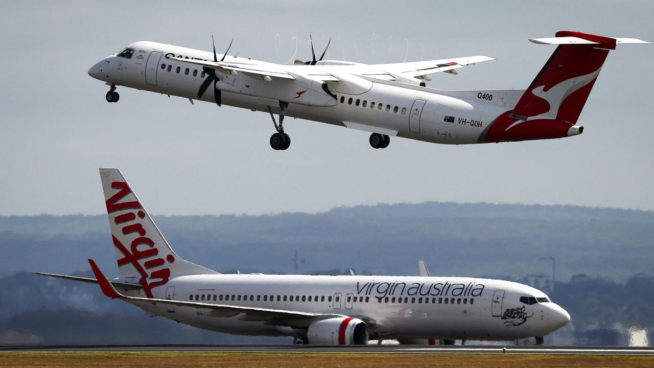 A Virgin Airways plane travels down the runway as a QantasLink Dash 8-400 series plane takes off at Sydney's Kingsford Smith international airport on November 3, 2023. (Photo by DAVID GRAY / AFP)