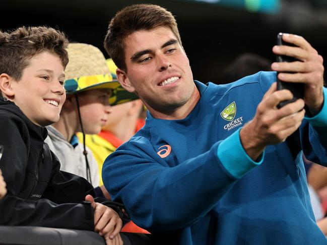 Australia's Xavier Bartlett poses for a selife with fans during the first one-day international (ODI) cricket match between Australia and the West Indies at the Melbourne Cricket Ground (MCG) in Melbourne on February 2, 2024. (Photo by Martin KEEP / AFP) / -- IMAGE RESTRICTED TO EDITORIAL USE - STRICTLY NO COMMERCIAL USE --