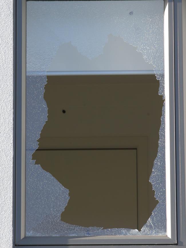 A bullet hole in the wall behind a broken window. Picture: David Crosling