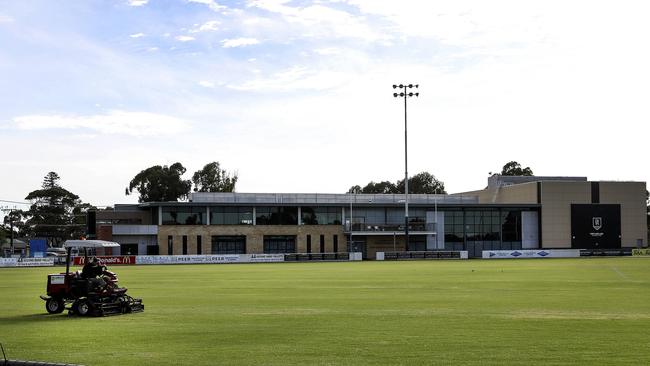 A groundsmen still works on the grass with the club headquarters in the background at Alberton Oval. Picture: Sarah Reed.