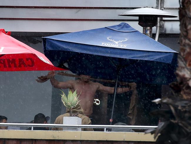 Bulldogs players arrive at the Harbour View Hotel in The Rocks for Mad Monday. A player rips off his shirt and throws it over the balcony. Picture: Toby Zerna
