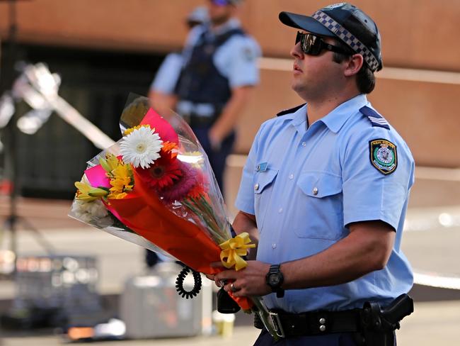 A police officer with a floral tribute at the scene this morning.. Photo:John Grainger