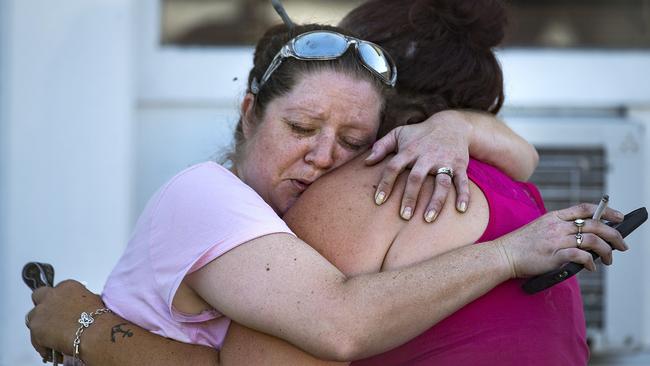 Carrie Matula embraces a woman after the shooting. Matula said she heard the shooting from the gas station where she works a block away. Picture: AP