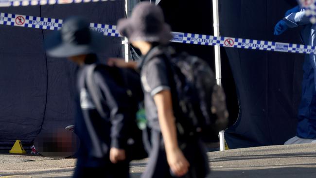 *PIXELATED VERSION*,  *EDITOR'S NOTE*****WARNING GRAPHIC IMAGERY***SYDNEY, AUSTRALIA - NewsWire Photos JULY 27, 2023: School kids walk past Forensics police and a dead body on the ground pictured at a crime scene on Broughton Street in Canterbury where a man was shot dead last night around 2am. Picture: NCA NewsWire