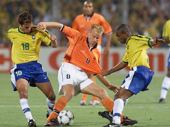 Dennis Bergkamp (C) challenged by Leonardo (L) while Cesar Sampaio (R) pulls his jersey during semi-final with Brazil.