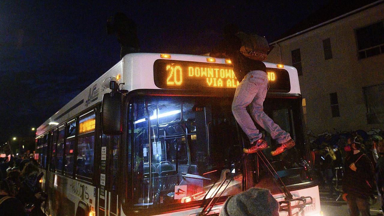 A demonstrator climbs atop a bus in Oakland, California, while protesting the death of George Floyd. Picture: AP/Noah Berger