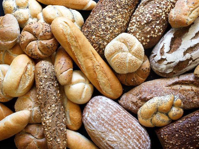 Many mixed breads and rolls shot from above.