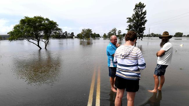 Residents stand by a flooded road in Lawrence, some 70km from the NSW town of Lismore on March 1, 2022. (Photo by SAEED KHAN / AFP)