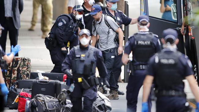 Passengers arriving at the Four Points Hotel in Brisbane under police guard.