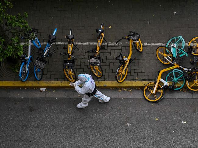 A policeman wearing personal protective equipment walks on a street in Shanghai on May 1, 2022. Picture: Hector Retamal/AFP