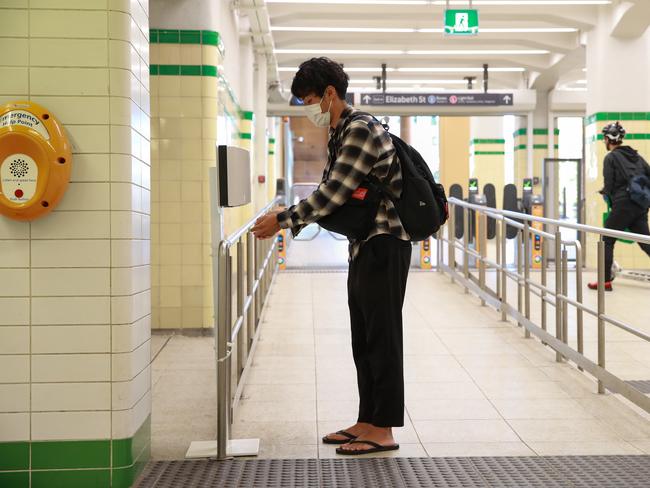 A traveller uses an automatic hand sanitiser at Central Station. Picture: Justin Lloyd.