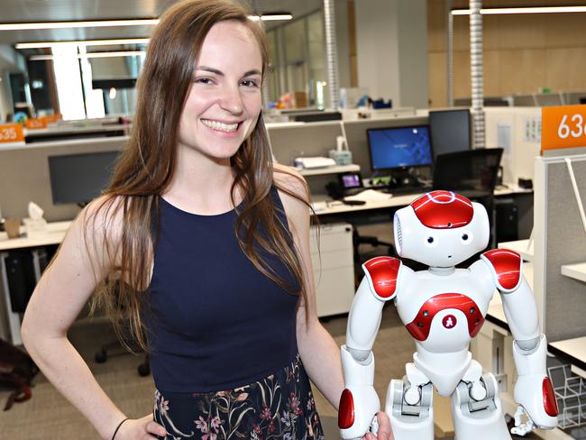 Nicole Robinson is a psychology PhD student at QUT who is working with robots. She is with "Andy". Pic Annette Dew