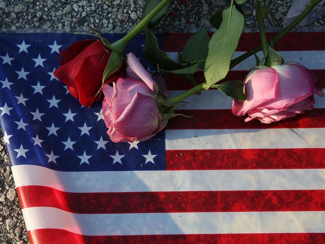 Flowers and an American flag are seen on the ground near the Pulse Nightclub where Omar Mateen killed 49 people on June 13, 2016 in Orlando, Florida.