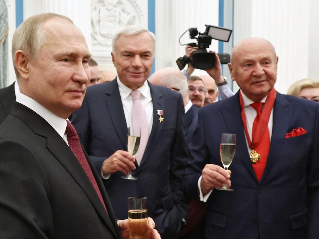 Russian President Vladimir Putin shares a drink with laureates after a state awards ceremony at the Kremlin in Moscow. Picture: AFP