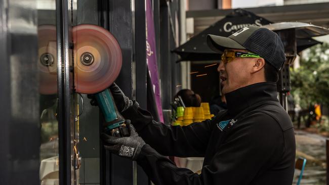 An angle grinder is used to cut through a lock on Oporto window door. Picture: Monique Harmer