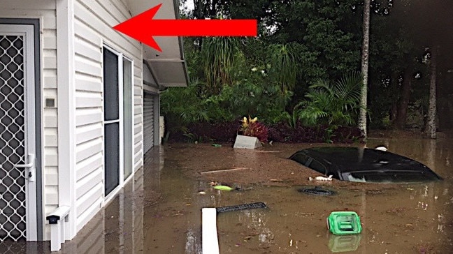 Mike Parkes’ home and submerged car. The red arrow shows how high the water reached.