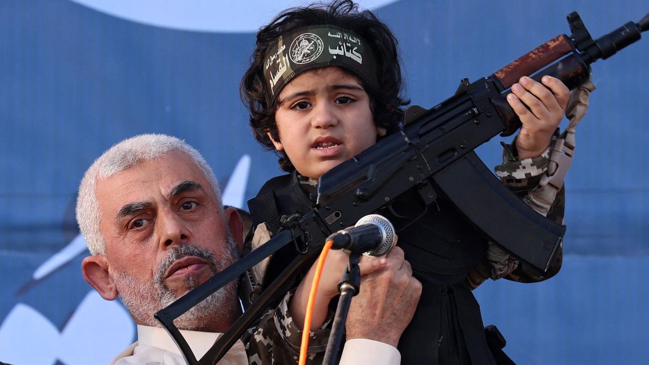 In 2021, Hamas leader Yahya Sinwar holds the child of an Al-Qassam Brigades fighter who was killed in fighting with Israel. Picture: Emmanuel Dunand/AFP