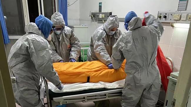 Medical workers preparing to take away the body of a Covid-19 victim in a hospital in Wuhan. Picture: AFP PHOTO / Zhang Hai