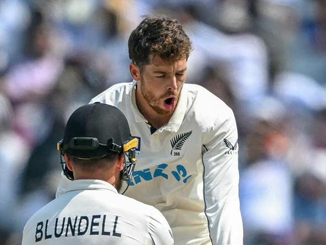 TOPSHOT - New Zealand's Mitchell Santner celebrates with his teammate Tom Blundell (L) after taking the wicket of India's captain Rohit Sharma during the third day of the second Test cricket match between India and New Zealand at the Maharashtra Cricket Association Stadium in Pune on October 26, 2024. (Photo by Punit PARANJPE / AFP) / -- IMAGE RESTRICTED TO EDITORIAL USE - STRICTLY NO COMMERCIAL USE --