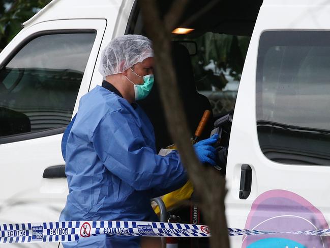 Police officers attend Hambledon State School at Edmonton, where a 3 year old was found dead in a Goodstart Early Learning Centre minibus at around 3:30pm on Tuesday. A police forensic officer inspects the van. PICTURE: BRENDAN RADKE